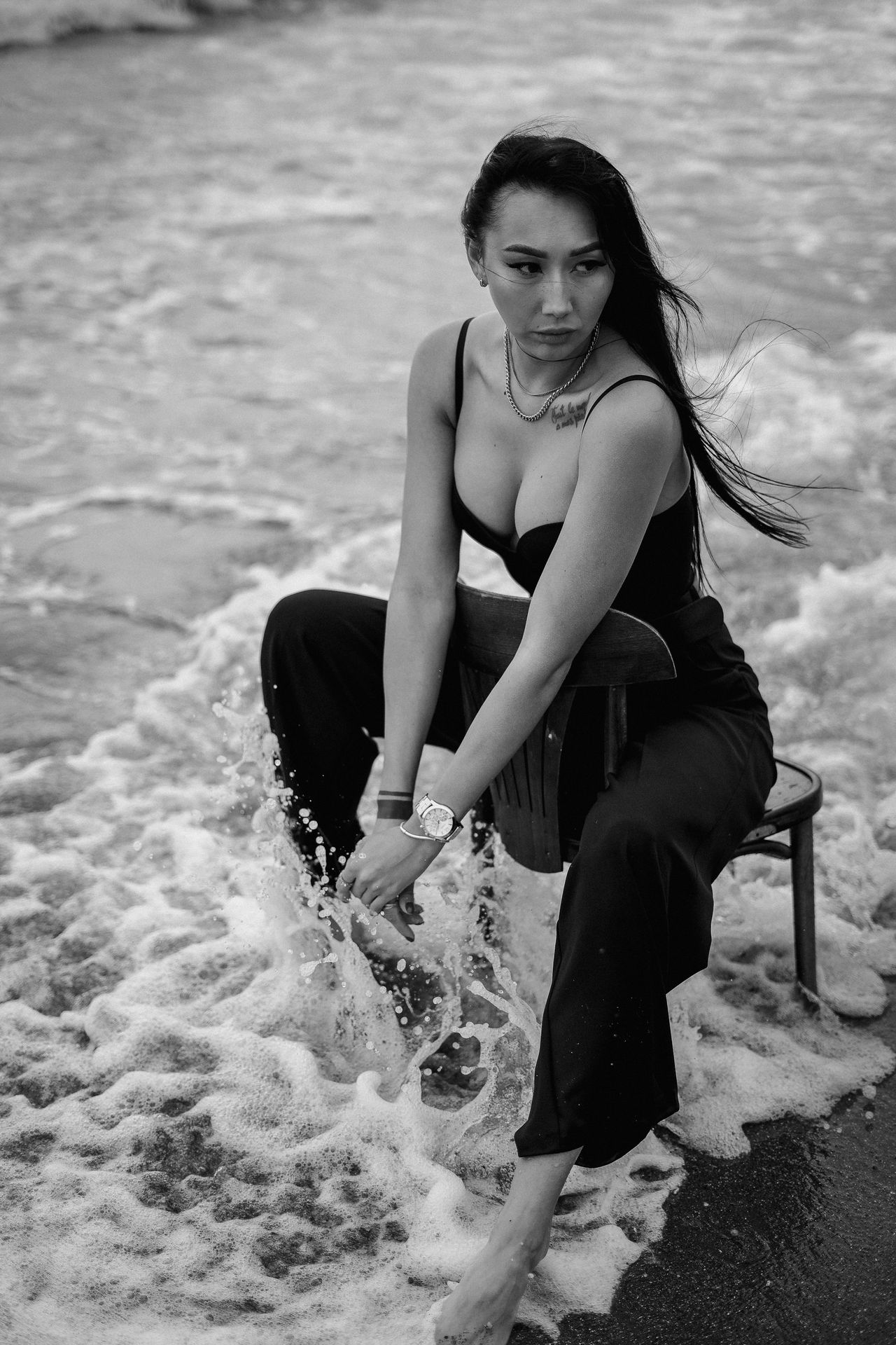 woman in black tank top sitting on chair on beach